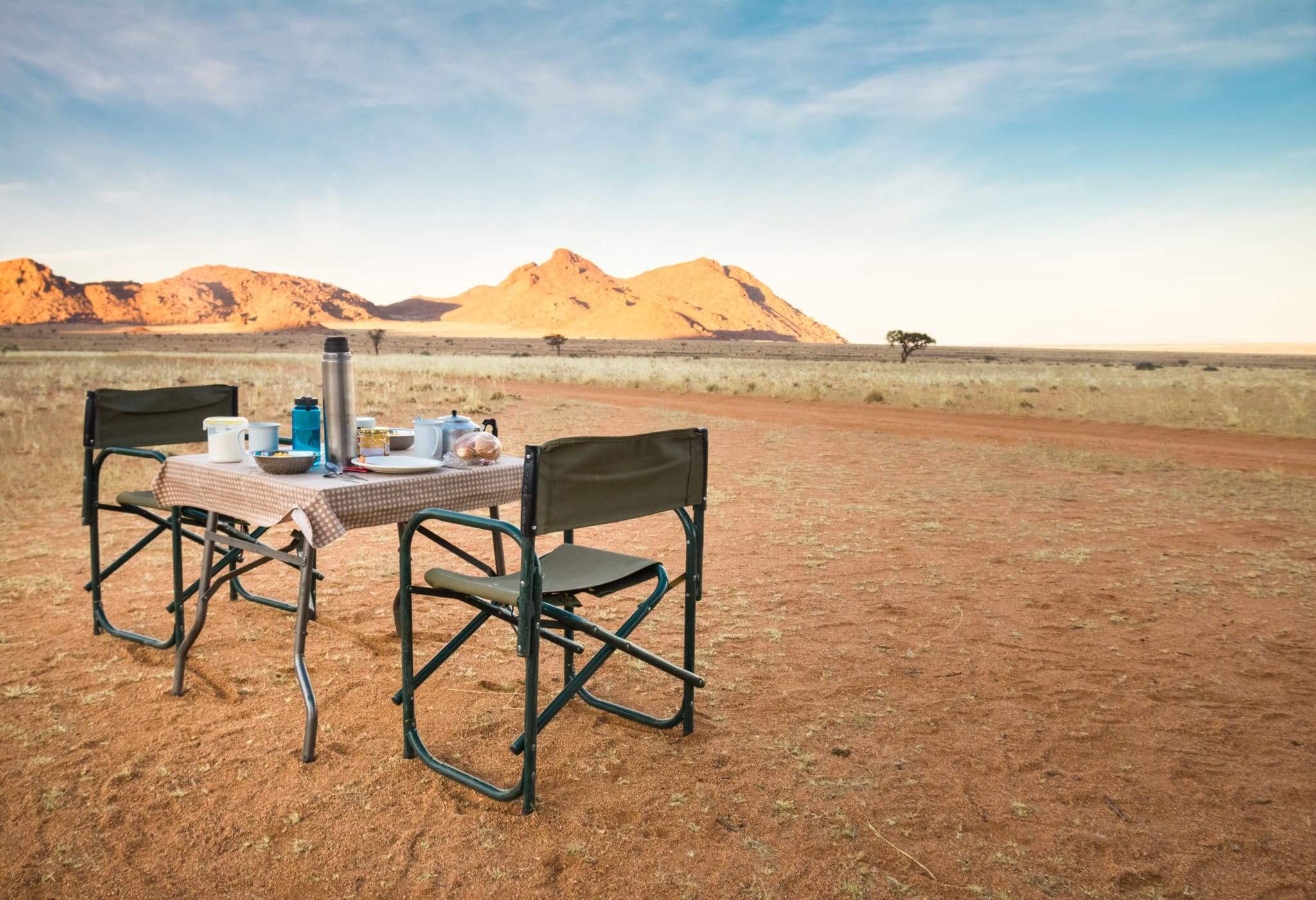 Camping table and chairs in the desert at sunrise