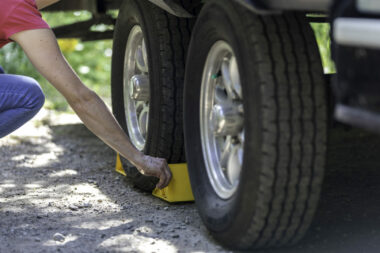 Woman placing RV tire chocks behind her wheels