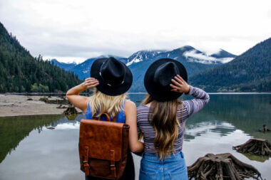 Two girls standing at edge of a lake in a national park while visiting on a free day.