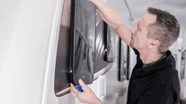 Man installs insulation to his RV windows.