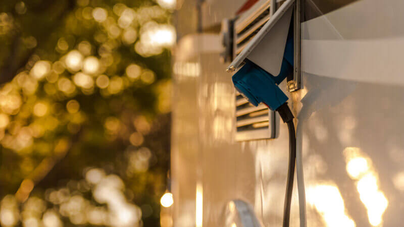 An RV is plugged in at a campsite and they're protecting their RV with a battery disconnect switch.