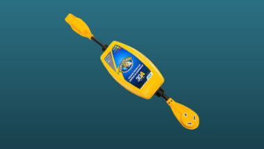 A camco 30 Amp Power Defender Surge Protector guard set against a dark blue background.
