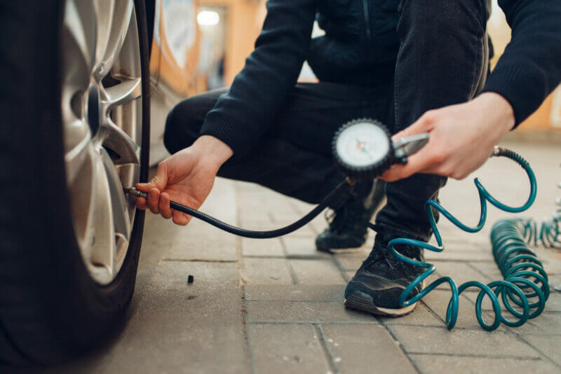Man checking tire pressure on RV.