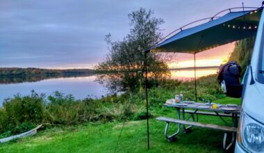 A camper at a beautiful campsite on the coast where is setting.