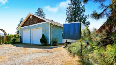A separate garage at a residence isn't big enough for the family RV so it is parked next to it.