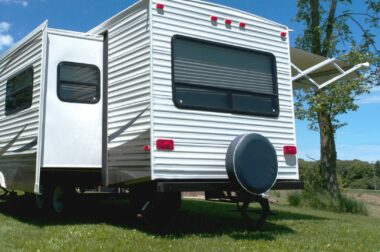 The view of a back of an RV with a spare tire covered and mounted to the back.