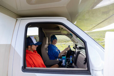 A happy new RV driver sits behind the steering wheel and is ready to hit the open road!