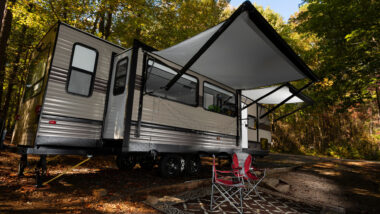 A travel trailer is camped out and jam packed with all the accessories to make the camping trip the best.