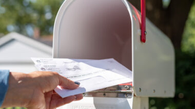 A person putting mail in a mailbox, with Americas Mailbox RVers have the option to use a USPS service for mail.