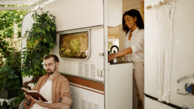 A couple in front of their travel trailer.