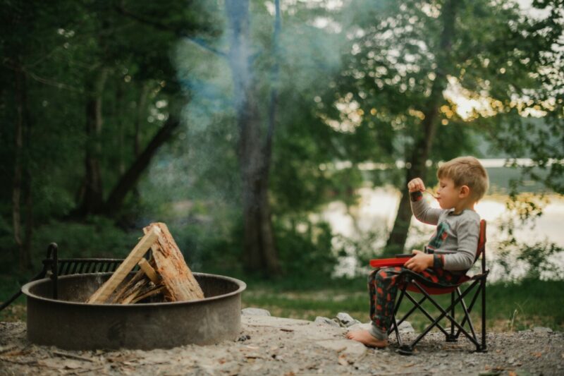 A young boy sitting in his kids camping chair