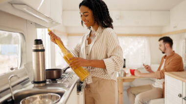 A woman in her kitchen cooking using a propane RV stove