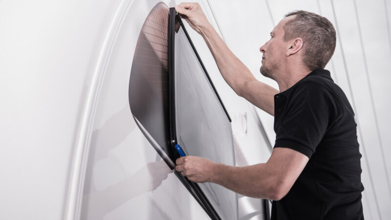 Man weather stripping his RV