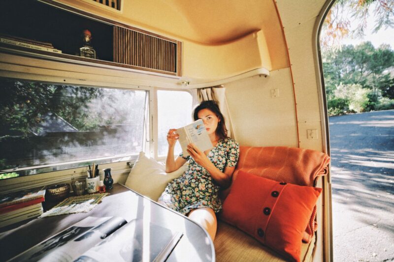 A girl reading a book on school bus conversion