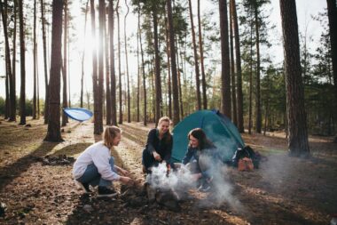 A group of girls using their camp kitchen in front of their tent