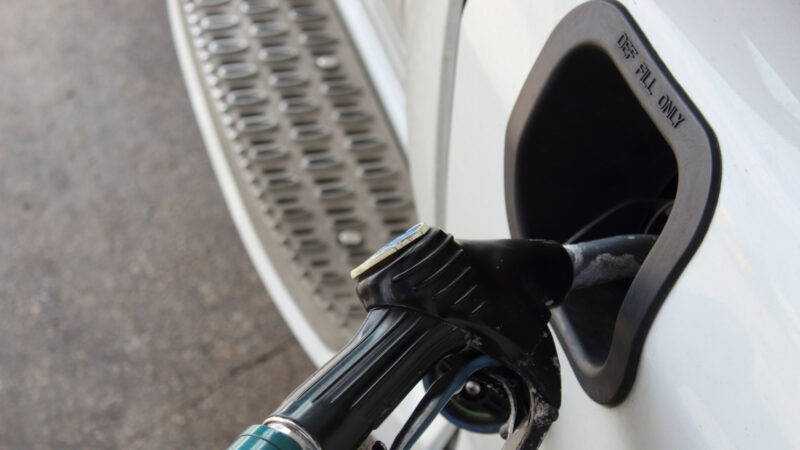 A car being filled up their DEF heads with DEF fluid at a gas station