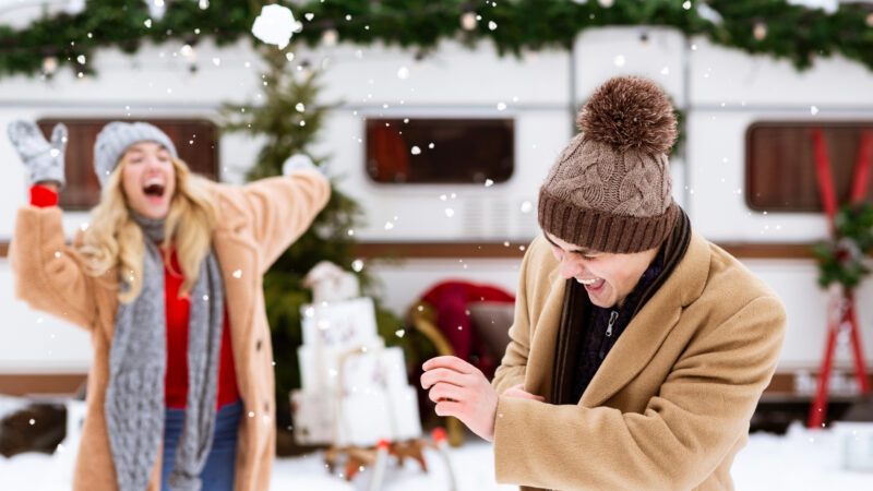 A couple playing in the cold weather outside of their best travel trailer