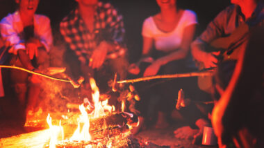 Friends sitting around the fire trying to figure out how to get smoke smell out of hair