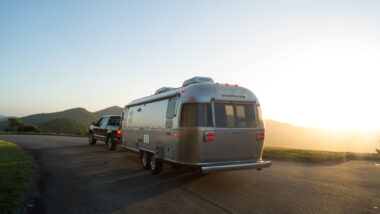 An Airstream Flying Cloud being towed by a truck.