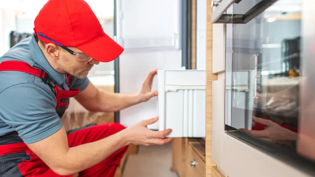 An inspector, looking into an appliance inside of an RV.