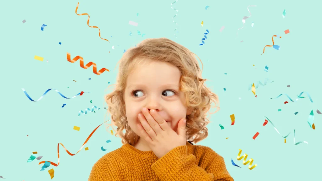 A child wearing an orange sweater, holding their hand over their mouth as they side-glance. The background is a light mint blue with confetti exploding behind the child.