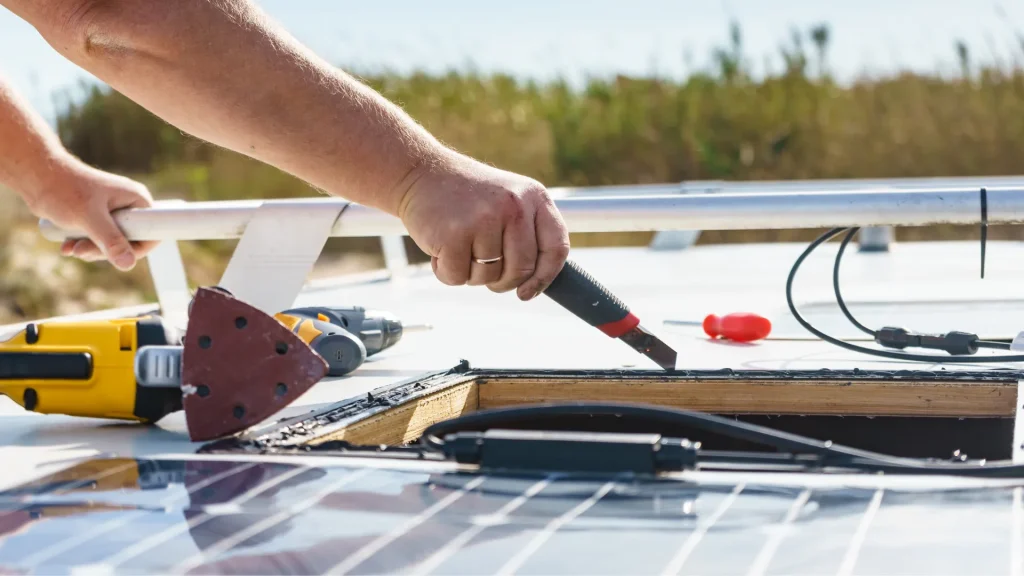 The installation of a skylight in on a caravan as a person takes a box cutter to the rooftop.