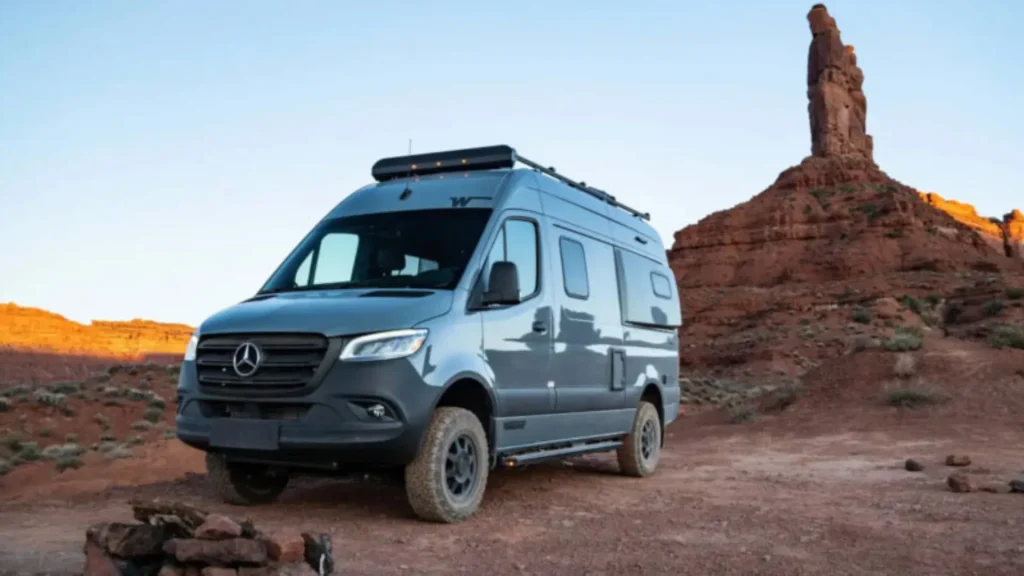 The Winnebago Revel in a red rocky desert landscape. 