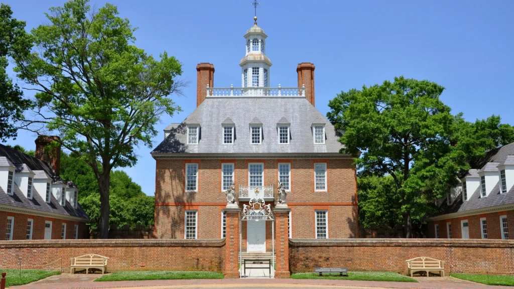 Governors Palace of B.C. Williamsburg, VA. It's a brick three story building with mature trees and a manicured lawn in the front.