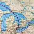 A map of the united states in beige and blue depicting the great lakes and the roadways, rivers, and lakes surround them.