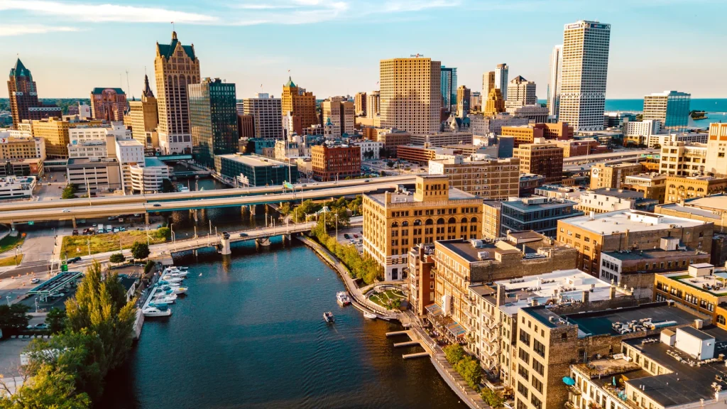 An aerial photo of downtown Milwaukee with the riverways and lake surround it. The juxtoposition of the downtown city and waterways gives life to the city.