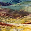 The Painted Hills in Oregon in colors of green, rusty reds, ochres, and oranges.