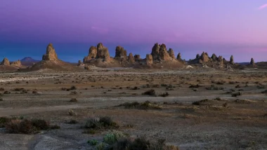 The Trona Pinnacles landscape at dusk with a blue and purple sky.