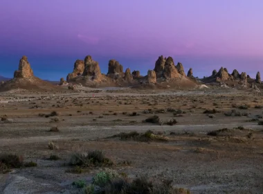 The Trona Pinnacles landscape at dusk with a blue and purple sky.