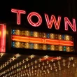 A theater sign lit up with bulbs and red neon as it says TOWN on the side of the overhang.