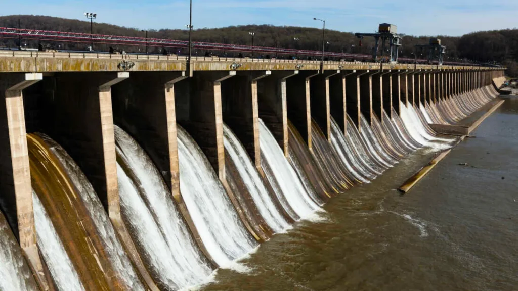 The Conowingo Dam near the Kilgore Falls. It spans across the body of water as water rushes through it. 