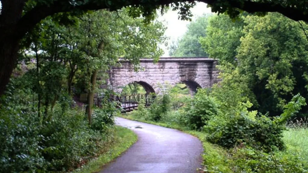 A section of the Grand Illinois Trail with a view of a bridge and dense foliage.