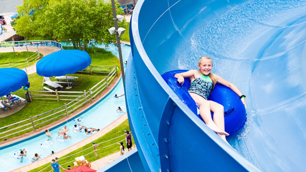 A child in a blue inner tube as it slides down a blue water slide in the SplashDown Waterpark near Burnside Farms.