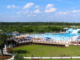 An aerial of a portion of the Buccaneer State Park. In it is a portion of the water park, bright blue sky, and green grass.