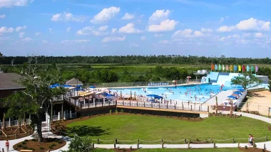 An aerial of a portion of the Buccaneer State Park. In it is a portion of the water park, bright blue sky, and green grass.