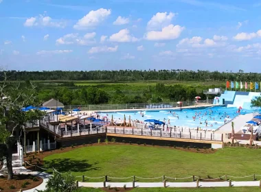 An aerial of a portion of the Buccaneer State Park. In it is a portion of the water park, bright blue sky, and green grass.