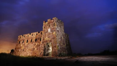 The Coronado Castle at night lit up against the dark purple sky.