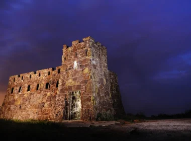 The Coronado Castle at night lit up against the dark purple sky.