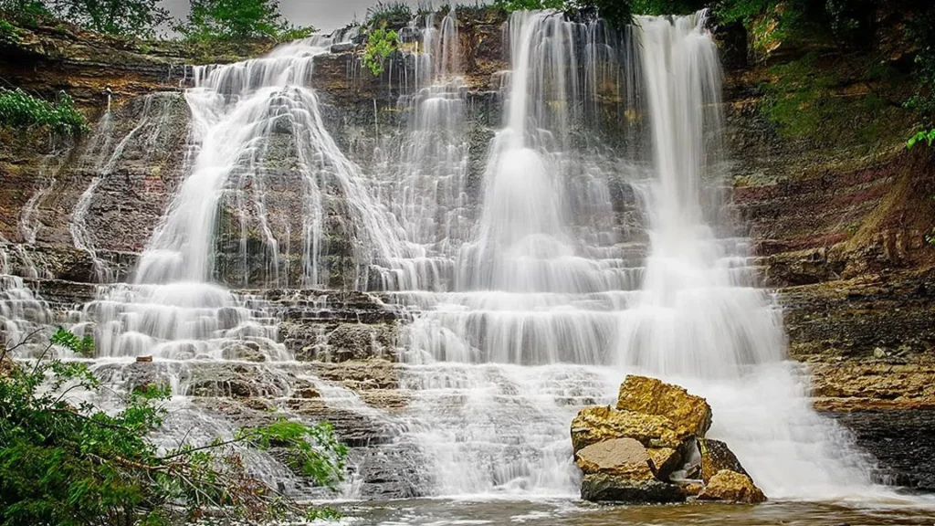 The tallest waterfall in Kansas, Geary Lake Falls. The water cascades down rocks that jut out from the cliff. 