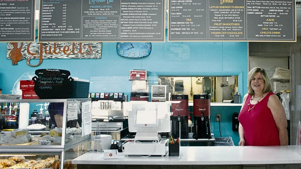 A photo of the interior of Jubelt's and their bakery. The wall is painted turquoise with multiple menus hanging above the counter. 